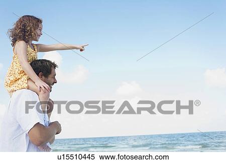 Stock Photography - Father carrying daughter on shoulders. Fotosearch