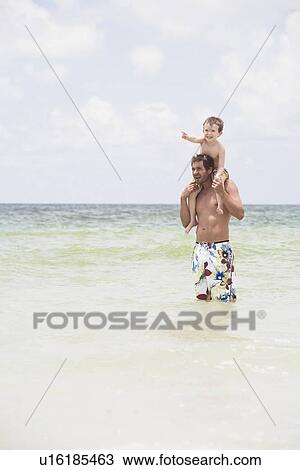 Father carrying son on shoulders in ocean View Large Photo Image Stock Image - Father carrying son on shoulders in ocean. Fotosearch
