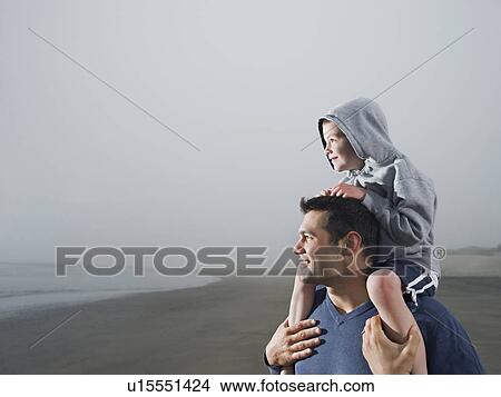 Father carrying son on shoulders on beach View Large Photo Image Picture - Father carrying son on shoulders on beach. Fotosearch