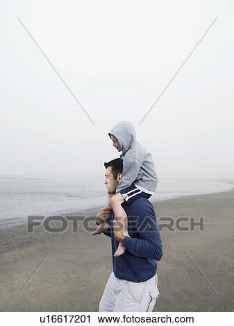 Father carrying son on shoulders on beach View Large Photo Image Stock Image - Father carrying son on shoulders on beach. Fotosearch
