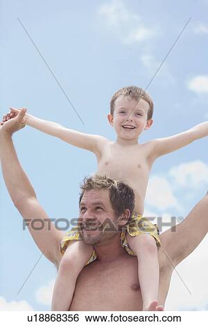 Stock Photograph - Father carrying son on shoulders. Fotosearch