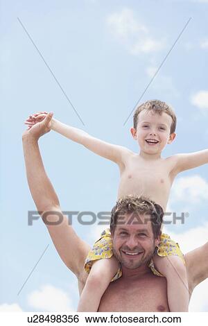 Stock Photograph - Father carrying son on shoulders. Fotosearch