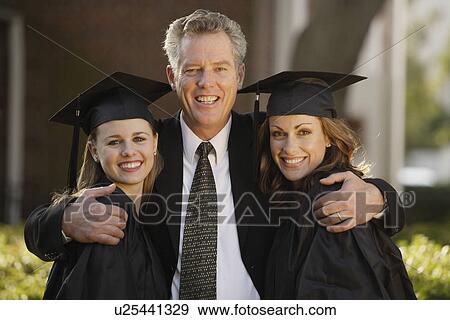 Stock Photo - Father hugging graduate daughters. Fotosearch