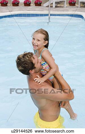 Father lifting daughter out of swimming pool View Large Photo Image Stock Photograph - Father lifting daughter out of swimming pool. Fotosearch