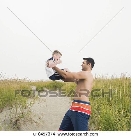 Father lifting son on beach View Large Photo Image Picture - Father lifting son on beach. Fotosearch