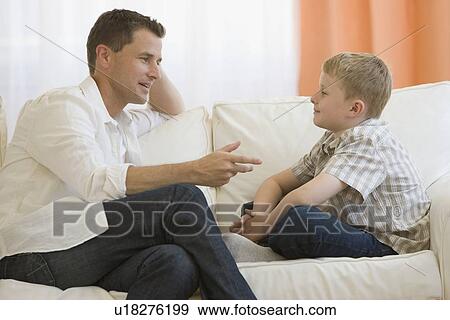 Father talking to son on sofa View Large Photo Image Stock Photo - Father talking to son on sofa. Fotosearch