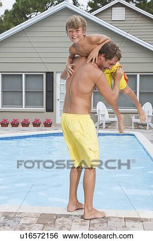 Father throwing son into swimming pool View Large Photo Image Stock Photograph - Father throwing son into swimming pool. Fotosearch