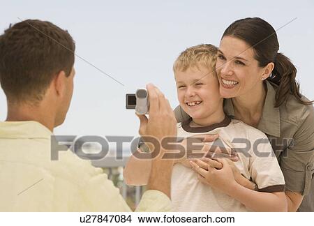 Picture - Father video recording wife and son. Fotosearch