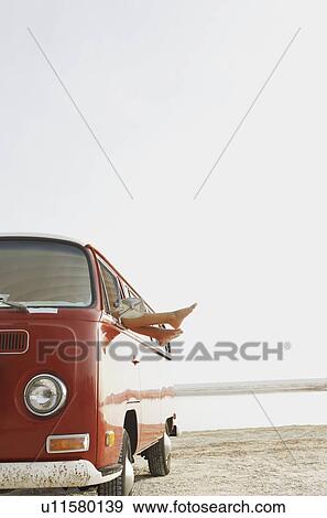 Stock Photo - Feet sticking out of van window on beach. Fotosearch