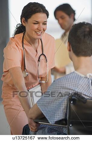 Stock Photo - Female doctor helping patient in wheelchair. Fotosearch