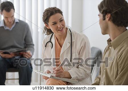 Female doctor in waiting room with male patient View Large Photo Image Stock Image - Female doctor in waiting room with male patient. Fotosearch