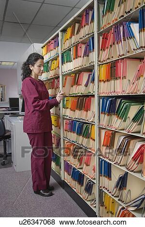 Stock Photo - Female doctor looking at charts. Fotosearch