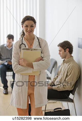 Stock Photo - Female doctor posing in waiting room. Fotosearch