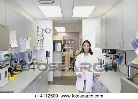 Stock Image - Female doctor standing in office. Fotosearch