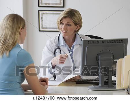 Stock Image - Female doctor talking to patient. Fotosearch