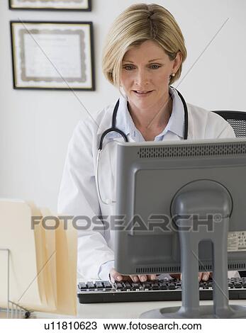Female doctor typing on computer View Large Photo Image Stock Image - Female doctor typing on computer. Fotosearch