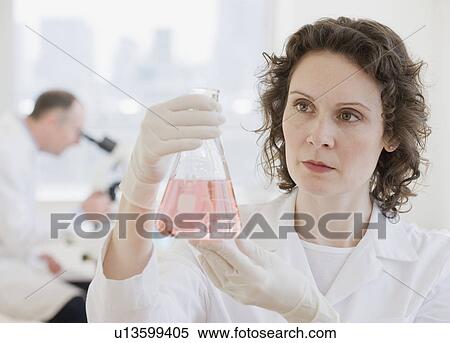 Female scientist looking at beaker of liquid View Large Photo Image Stock Photography - Female scientist looking at beaker of liquid. Fotosearch