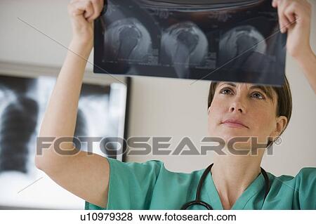 Stock Photo - Female technician examining x-ray. Fotosearch