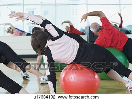 Stock Image - Fitness class stretching on balance balls. Fotosearch