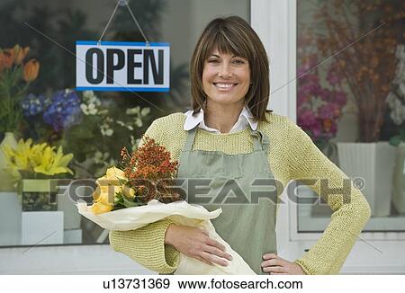 Florist holding bouquet outside florist shop View Large Photo Image Stock Photo - Florist holding bouquet outside florist shop. Fotosearch