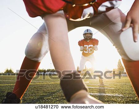 Football center preparing to snap football to quarterback View Large Photo Image Stock Image - Football center preparing to snap football to quarterback. Fotosearch