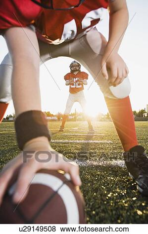 Football center preparing to snap football to quarterback View Large Photo Image Stock Photo - Football center preparing to snap football to quarterback. Fotosearch