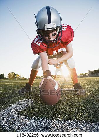 Stock Photograph - Football center ready to snap football. Fotosearch