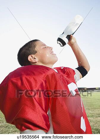 Picture - Football player spraying water on face. Fotosearch