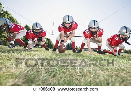 Football players at line of scrimmage ready to snap football View Large Photo Image Stock Photo - Football players at line of scrimmage ready to snap football. Fotosearch