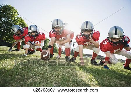 Football players at line of scrimmage ready to snap football View Large Photo Image Stock Photo - Football players at line of scrimmage ready to snap football. Fotosearch
