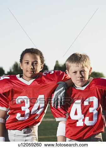 Stock Image - Football players posing on field. Fotosearch