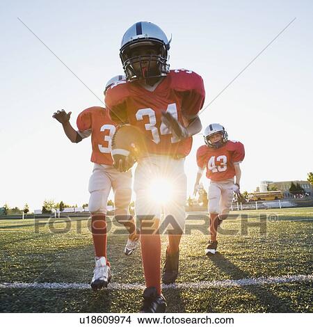 Football players running on field View Large Photo Image Picture - Football players running on field. Fotosearch