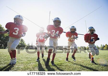 Stock Photography - Football players running on field. Fotosearch