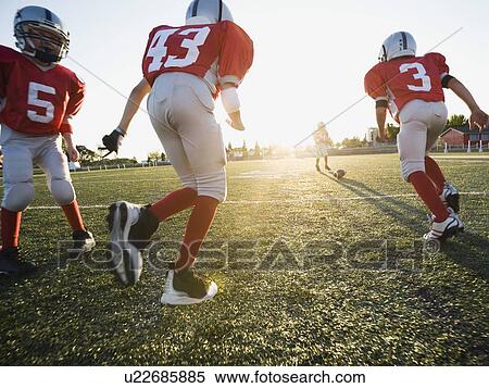 Football players running on field View Large Photo Image Stock Photography - Football players running on field. Fotosearch