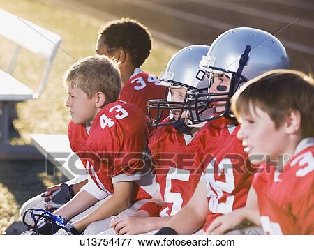 Stock Photo - Football players sitting on bench. Fotosearch