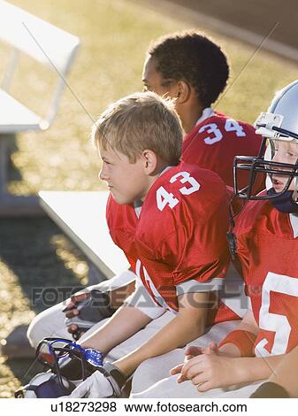 Stock Photo - Football players sitting on bench. Fotosearch