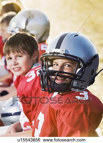 Stock Photograph - Football players sitting on bench. Fotosearch