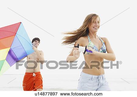 Friends flying kite on beach View Large Photo Image Stock Photo - Friends flying kite on beach. Fotosearch