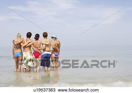 Friends hugging and standing in ocean View Large Photo Image Stock Image - Friends hugging and standing in ocean. Fotosearch