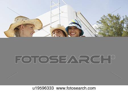 Stock Image - Friends laughing near motor home on beach. Fotosearch