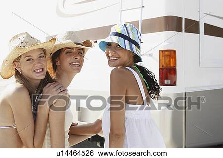 Stock Photograph - Friends laughing near motor home on beach. Fotosearch