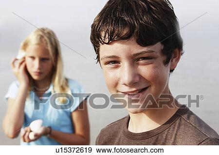 Stock Photo - Friends looking for shells on beach. Fotosearch