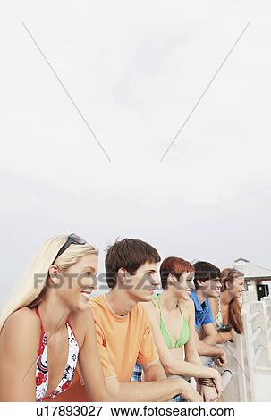 Friends posing on boardwalk railing View Large Photo Image Stock Photo - Friends posing on boardwalk railing. Fotosearch