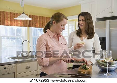 Stock Image - Friends preparing dinner. Fotosearch
