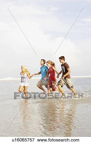 Friends running in ocean View Large Photo Image Stock Photo - Friends running in ocean. Fotosearch
