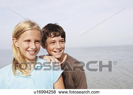 Stock Photo - Friends smiling at beach. Fotosearch