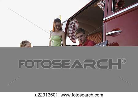Friends socializing around van on beach View Large Photo Image Stock Image - Friends socializing around van on beach. Fotosearch