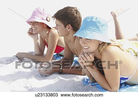 Friends sunbathing on beach View Large Photo Image Stock Image - Friends sunbathing on beach. Fotosearch