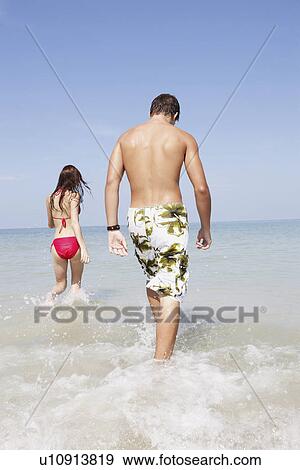 Friends walking in ocean View Large Photo Image Stock Photo - Friends walking in ocean. Fotosearch