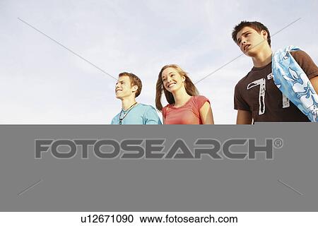 Stock Image - Friends walking on beach. Fotosearch